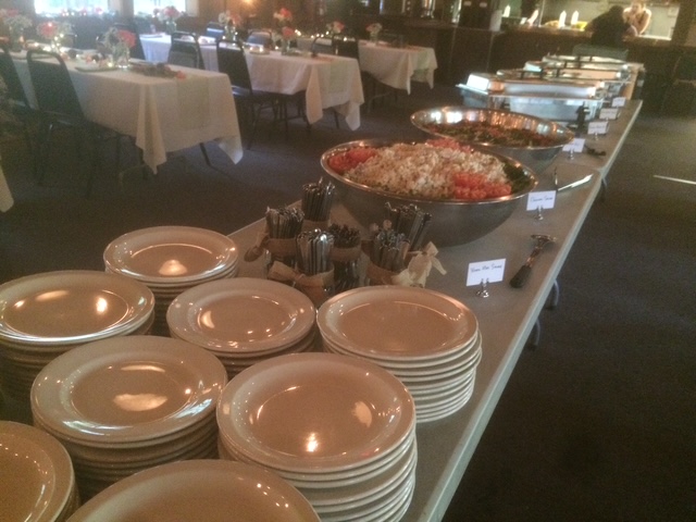 Banquet hall buffet line with stacked plates and serving bowls