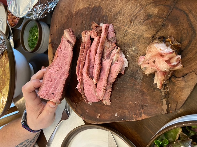 Sliced smoked beef on a carving board