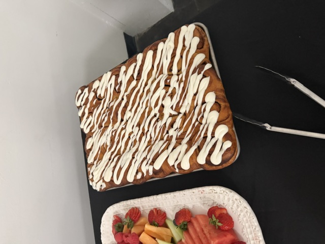 Tray of iced cinnamon rolls at an event