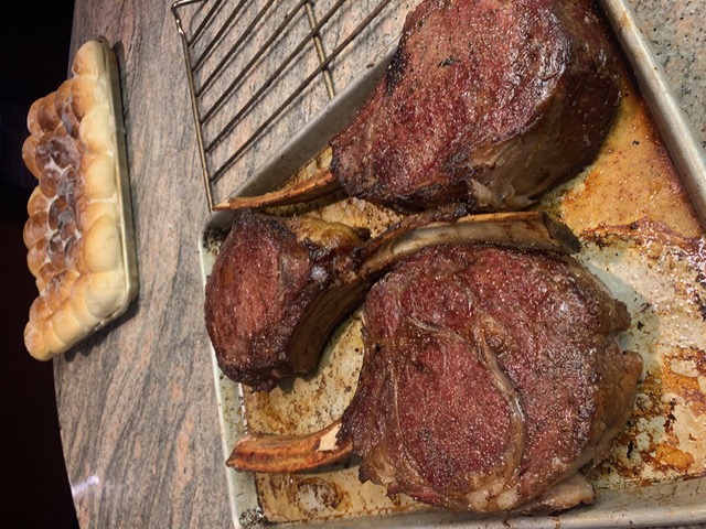 Bone-in tomahawk ribeye steaks fresh off the fire